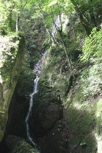 皆坂の滝が勢いよく上から下へ流れている写真