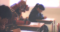 教室で受験勉強する甲冑を着た少年が写る「落ちない城 白旗城」の動画の切り抜き