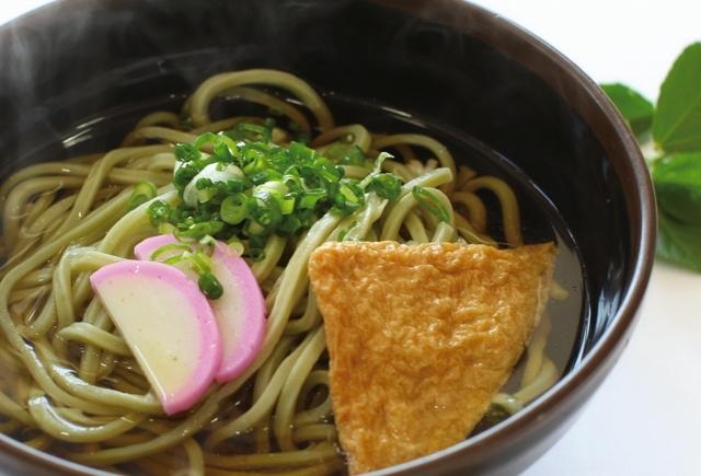 画像：ネギとかまぼこと油揚げが入った薄い緑色をした麺のうどん(上郡町の特産品「円心モロどん」)の写真