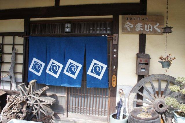 かみごおりの古民家に移り住んだ、「生活骨董の店やまいく」さんの看板とのれんを含む入口まわりの写真画像