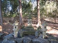 林の中にある石の塔（五輪塔）が3つ並んだ画像